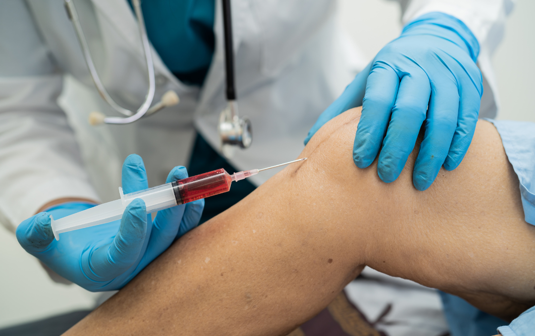 Doctor giving a cortisone shot in the patient's knee.