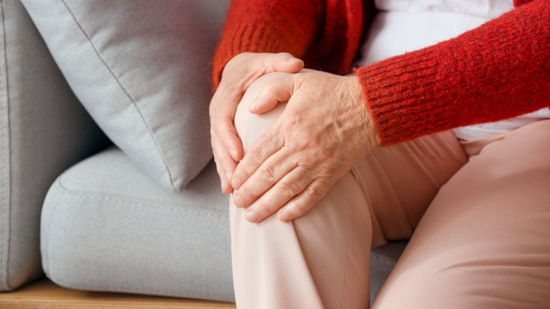 Person having knee pain while sitting for too long.