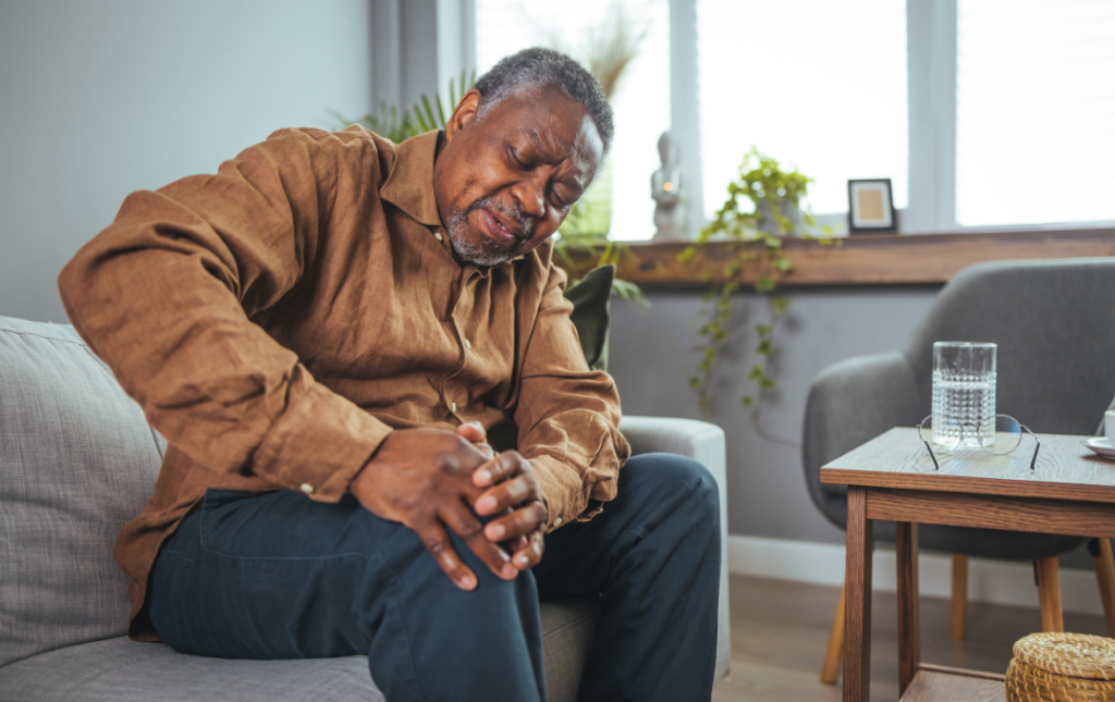 Man experiencing knee pain due to prolonged sitting in one position.