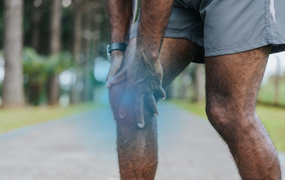 Older adult holding knee while standing up with stiffness